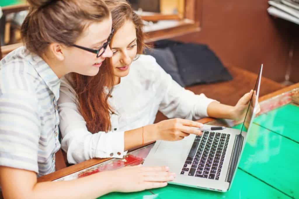 two young women looking at computer