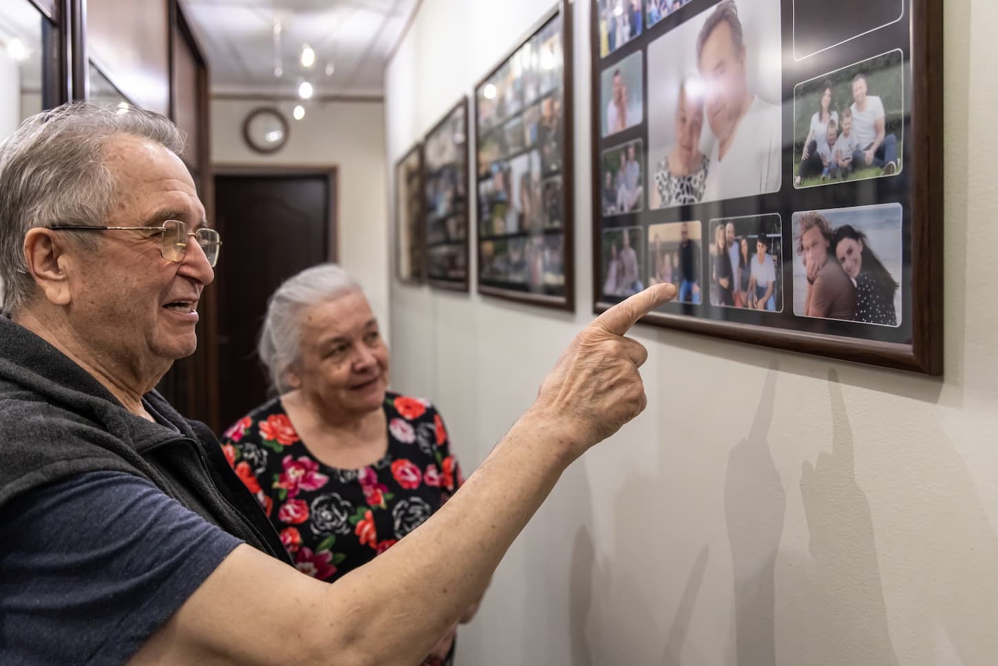 An image of an elderly man and woman are looking at family photographs.