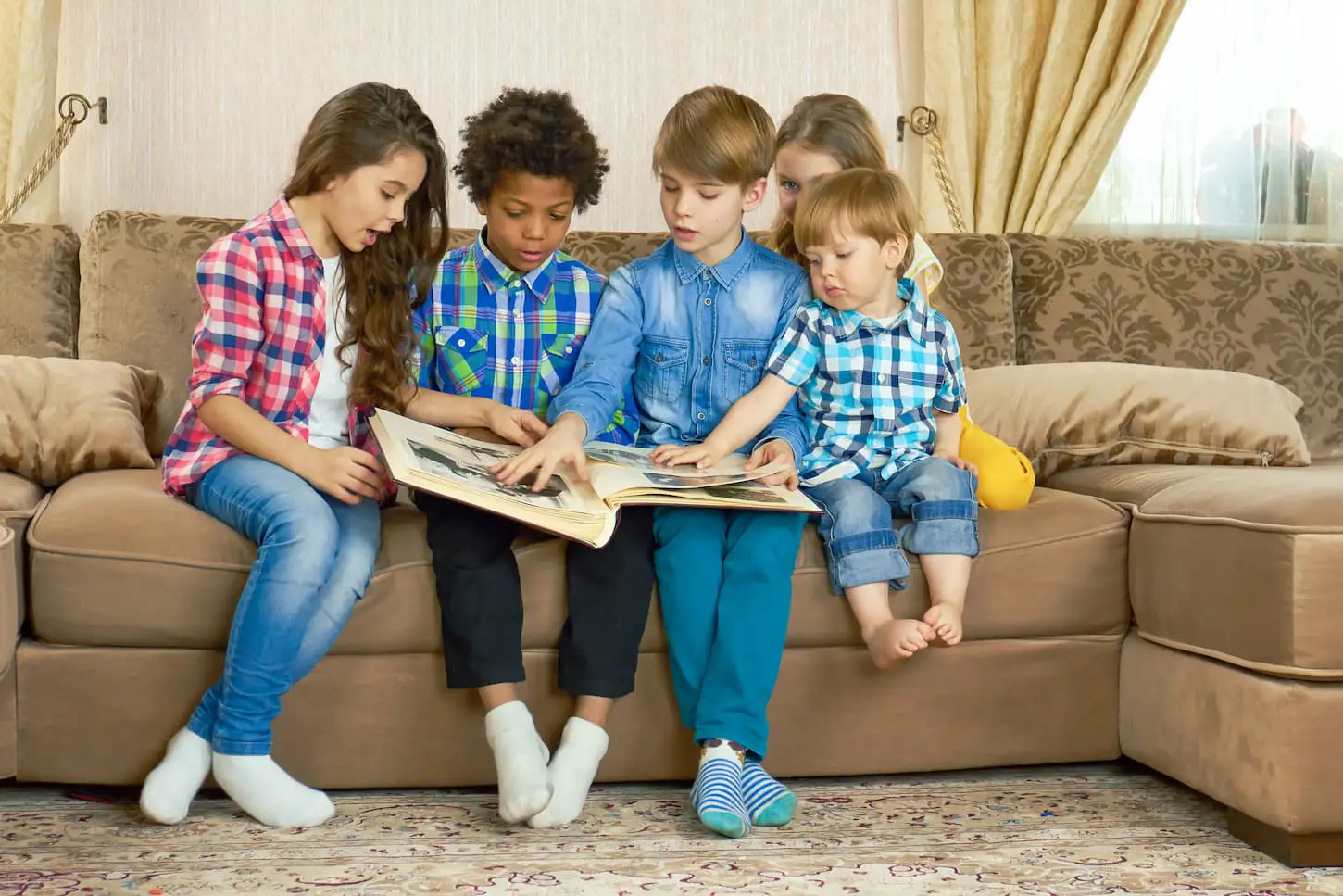 An image of kids in a room looking through a photo album.