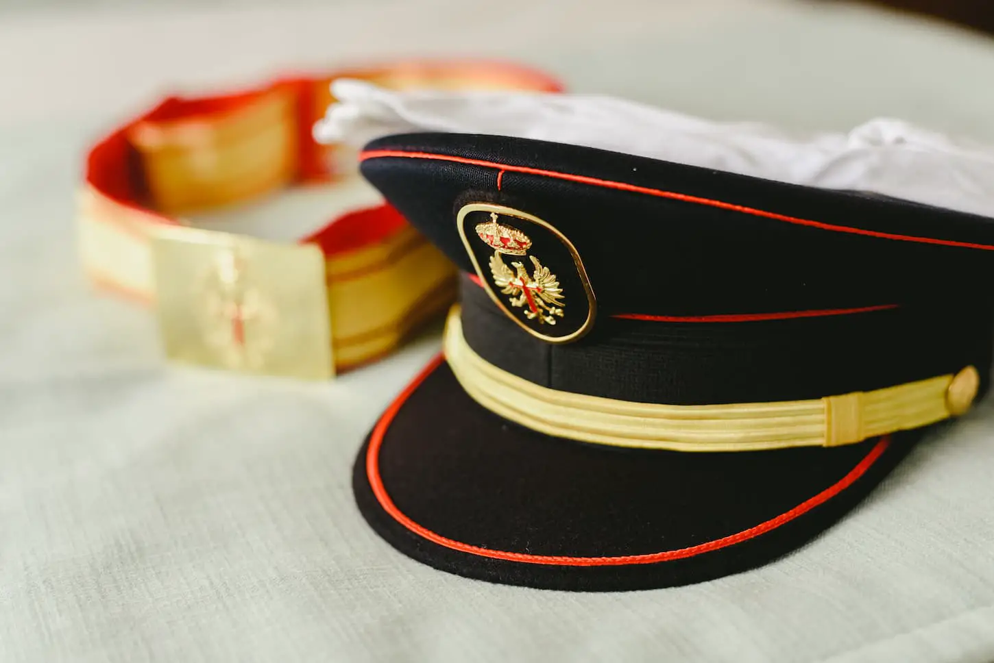 An image of the captain's cap and belt of military uniform.