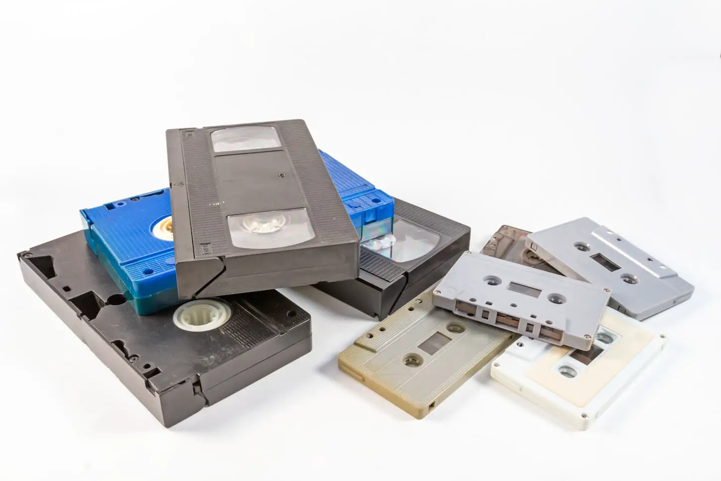 An image of old video cassettes and Audiotape cassettes on a white background.